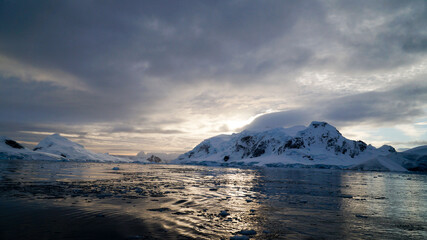 Icebergs in the oceans near Paradise Bay on an overcast day with dark mood in Antarctica.