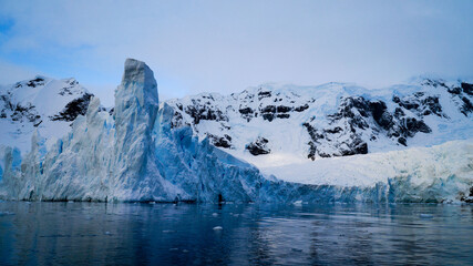 Fototapeta na wymiar Icebergs in the oceans near Paradise Bay on an overcast day with dark mood in Antarctica.