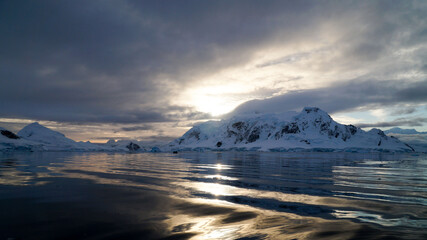 Icebergs in the oceans near Paradise Bay on an overcast day with dark mood in Antarctica.