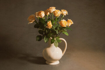 A bunch of pale roses in a porcelain vase against old paper background. Classic Vintage style. 