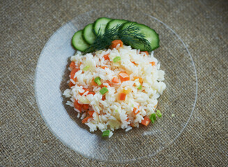 Boiled rice with vegetables on a transparent plate