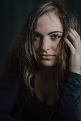 portrait of a beautiful Italian girl with long hair with her hand in her hair with a seductive look