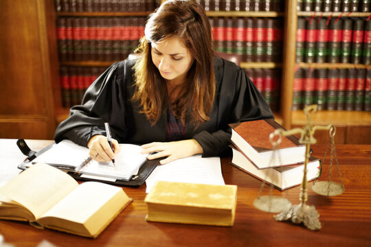 Shes an expert in the legal world. Shot of a young legal professional sitting at her desk in a study.