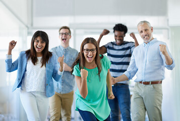 We did it. Cropped portrait of a group of businesspeople cheering in an office.