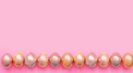 Golden eggs on a pink background . Easter Concept