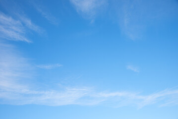 soft sky with fluffy cirrus clouds, blue space in the middle