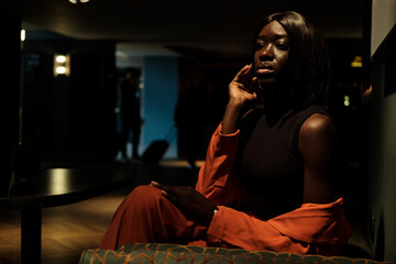 Young black woman is looking away in a lobby hotel.