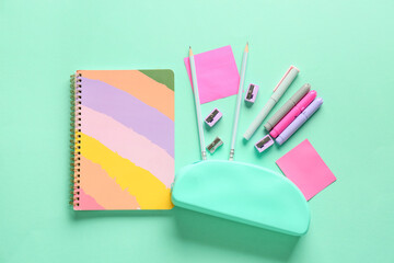 Composition with stylish pencil case and different stationery on color background