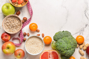Different healthy products with nuts and measuring tape on light background
