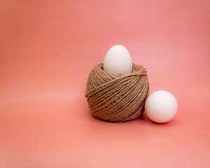 white eggs in a june basket on a bright pink background