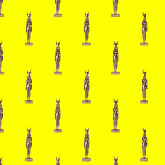 Isis figurine seamless pattern on yellow background.