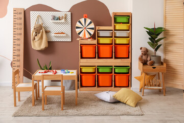 Interior of stylish children's playroom with toys and pegboard