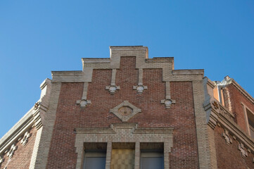 Fototapeta na wymiar cornice of a brick building with windows and ornaments
