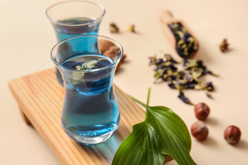 Cups of blue tea on color background, closeup