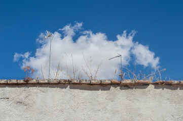 white wall with a sky and cloud behind