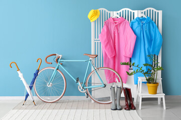 Folding screen with raincoats, gumboots, umbrellas and bicycle in hallway