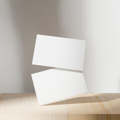 Blank business cards mockup on wooden table. Sunny shadow on wall background. 3D illustration...