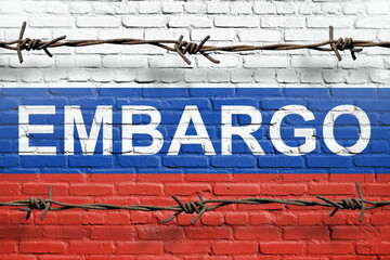 Flag of Russia painted on a brick wall with word embargo