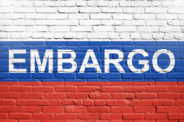 Flag of Russia painted on a brick wall with word embargo