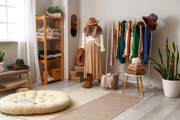 Interior of light dressing room with mannequin, rack and warm sweaters