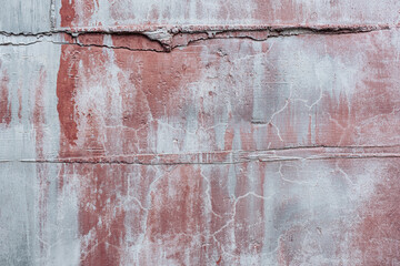 Texture of gray-pink cement wood surface. Faded background with cracks and smudges of paint