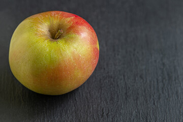 ripe juicy apple grown in a personal garden on a slate board close up