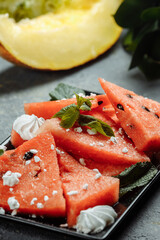 Pieces of fresh red watermelon on a black plate