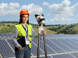 Female geodetic surveyor on a photovoltaic solar panel farm
