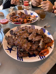 Plate of beef Kebab with slices or onions and tomatoes