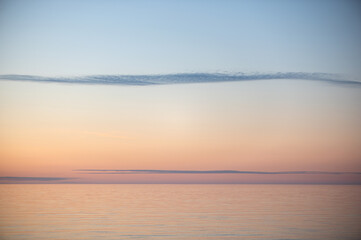 Fototapeta premium Meditation ocean and sky background. Colorful horizon over the water. Water surface. Abstract cloudscape over the sea, sunrise shot