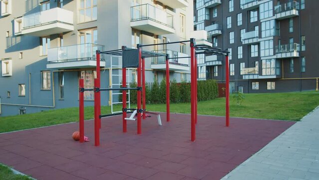 Outdoor sports ground without people. Iron horizontal bar, crossbar, parallel bars. Near building. Close up.