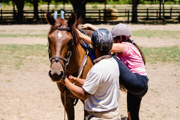 riding instructor, teaching a young woman how to get on the horse