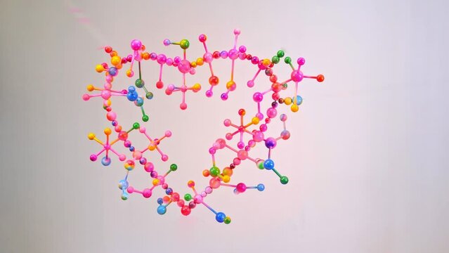 Colorful spheres balls like atoms..colors from atom of heart shape are dripping construction of molecular in heart shape .decorate with pink tone color. love story background...