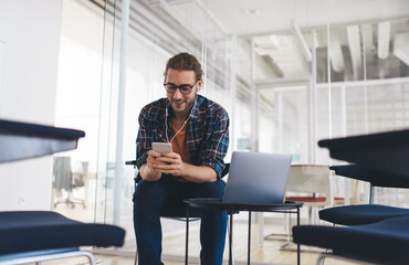 Millennial male copywriter searching information for text article using modern technology and...
