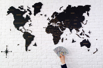 Hand holding money with map of the world on the background