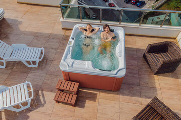 Drone view. Portrait of young carefree happy smiling couple relaxing at hot tub during enjoying...