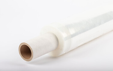 Roll of plastic stretch film with clear wrap. It stands in an isolated environment. It is used in the packaging of products.