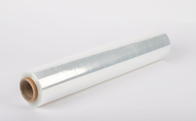 Roll of plastic stretch film with clear wrap. It stands in an isolated environment. It is used in the packaging of products.