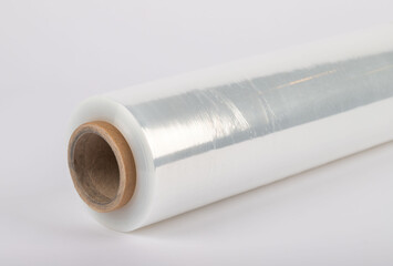 Roll of plastic stretch film with clear wrap. It stands in an isolated environment. It is used in the packaging of products.