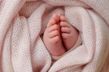 Small beautiful legs of a newborn baby in the first days of life