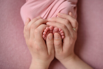 Small beautiful legs of a newborn baby in the first days of life