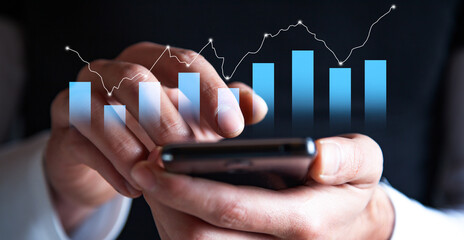 Businessman hand holding of mobile phone and showing a graph