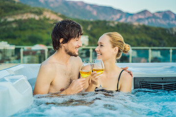 Portrait of young carefree happy smiling couple relaxing at hot tub during enjoying happy traveling moment vacation life against the background of green big mountains