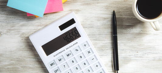 Calculator with papers and cup of coffee