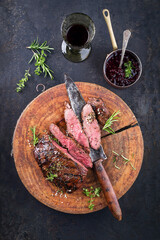 Traditional barbecue venison siloin steak roast with cranbarry sauce served as top view on a rustic...