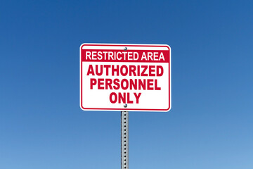 Restricted Area, Authorized Personnel Only, street sign with blue sky background
