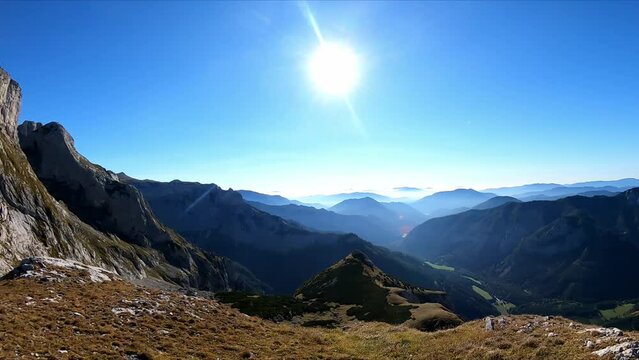 A panoramic view on the mountain peaks of the Hochschwab Region in Upper Styria, Austria. Cloudless weather on a sunny summer day in the Alps. Blue valley and sharp rocky summits. Concept freedom
