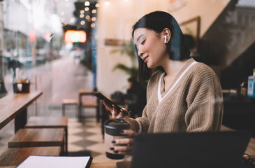 Young millennial asian girl working in cafe