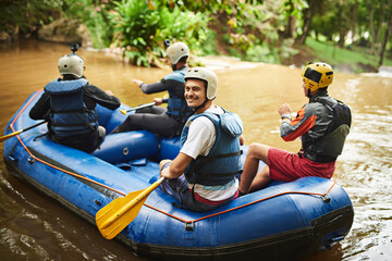 And so it begins.... High angle portrait of a handsome young man and his friends sitting in their white water raft. - obrazy, fototapety, plakaty