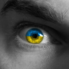 Close up of a male eye in the color of the Ukrainian flag.